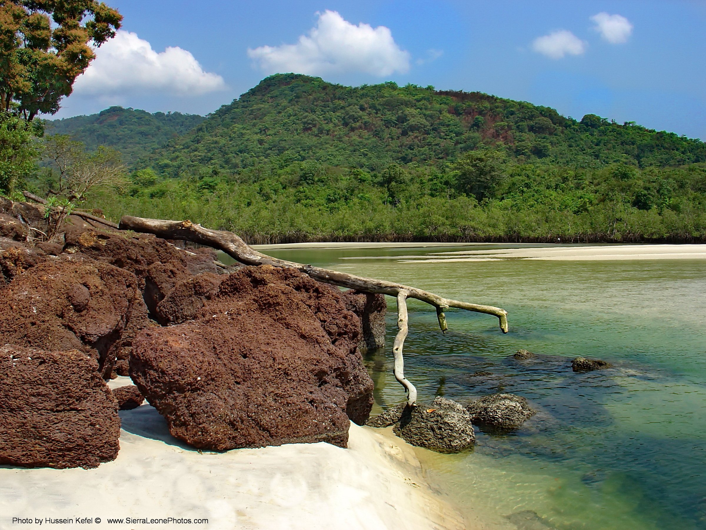 Laterite rock and the mangrove-lined river mouth at River Number Two Beach